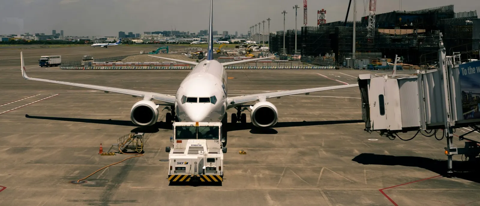 Passenger aircraft parked at a terminal gate beside a boarding bridge